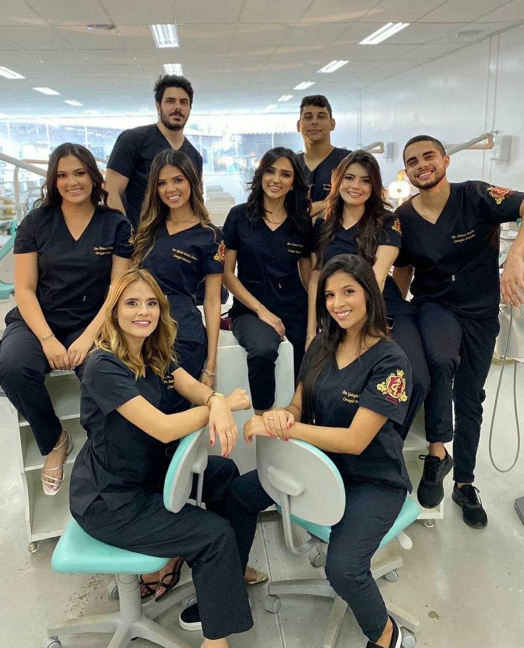 Grupo de estudantes de odontologia com scrubs pretos personalizados em clínica